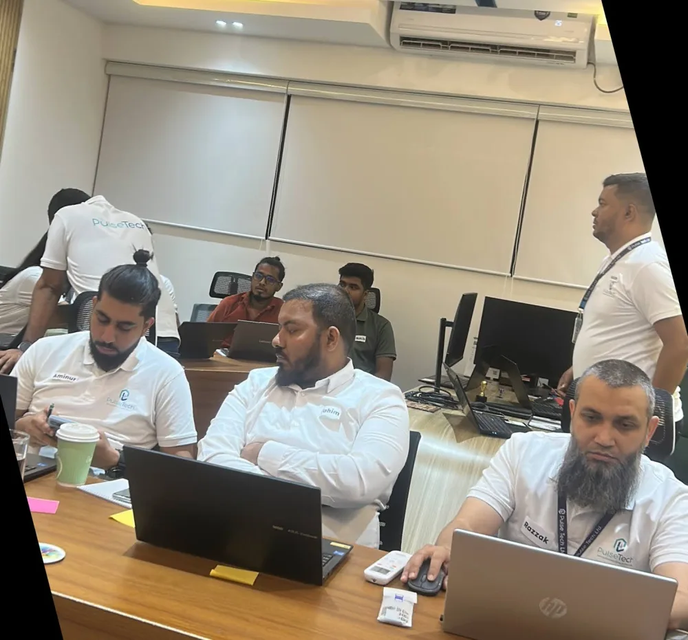 Executives and senior managers in an AimHuge leadership workshop, heads-down on laptops